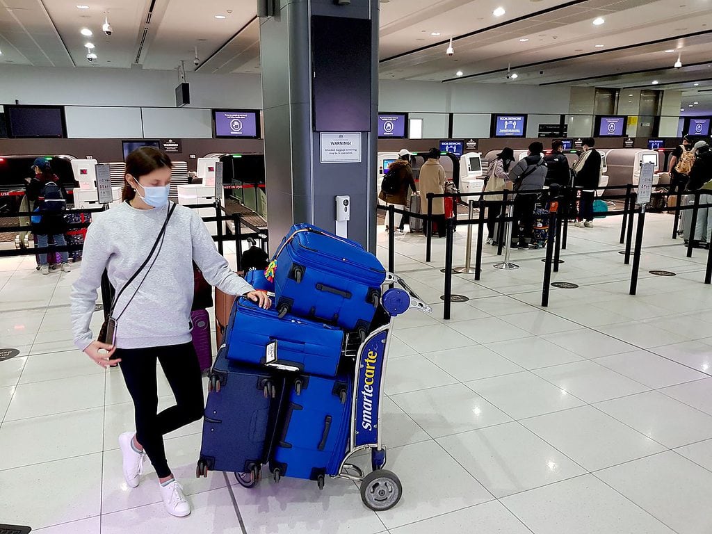 Our luggage on a luggage trolley at airport check-in while moving abroad