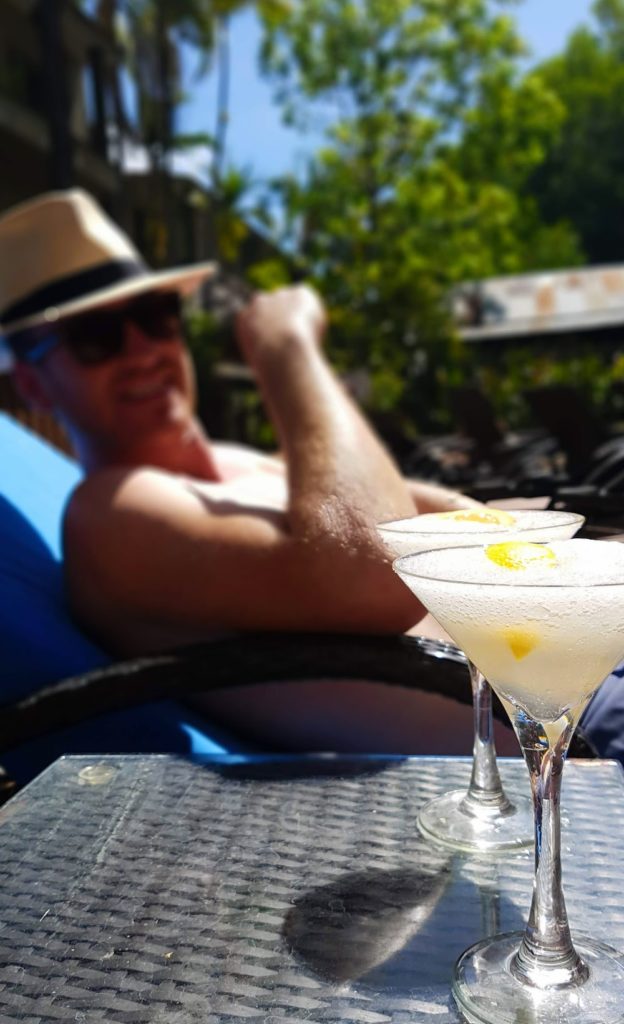 man sitting poolside with a frozen cocktail