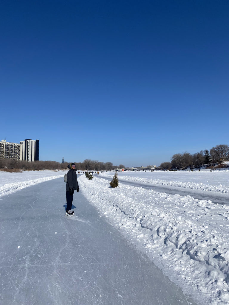 man ice skating on a frozen river