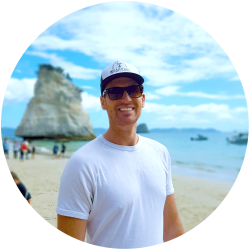 About Us, Mike standing on a beach in New Zealand